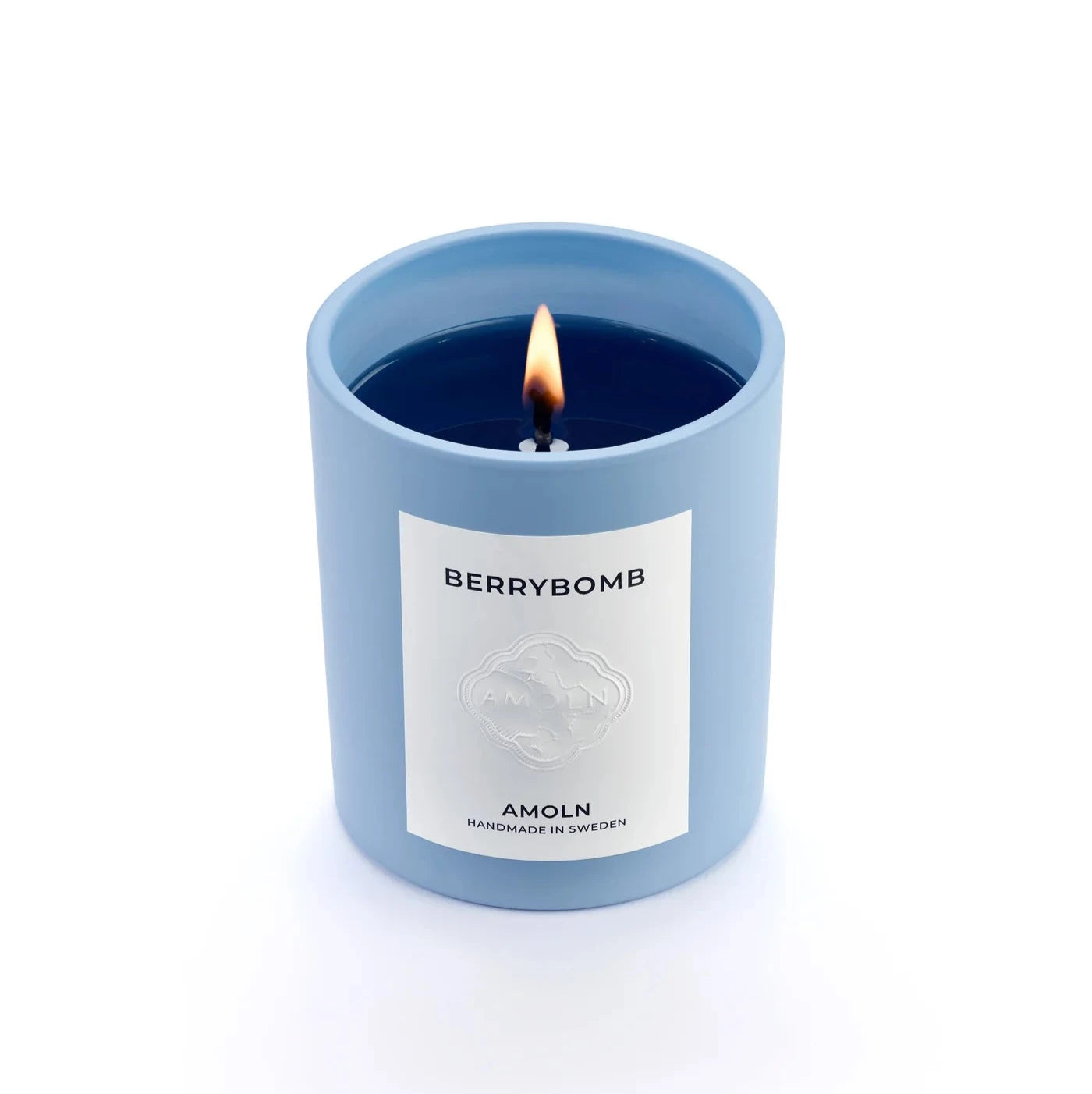 A blue candle with a label that reads 'berrybomb amoln' and has a branding symbol on it.