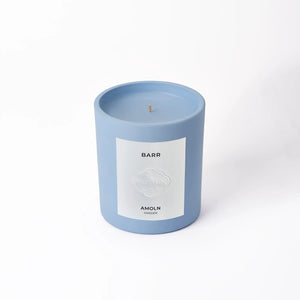 A blue candle with a label that reads 'BARR' and 'AMOLN' on a white background.