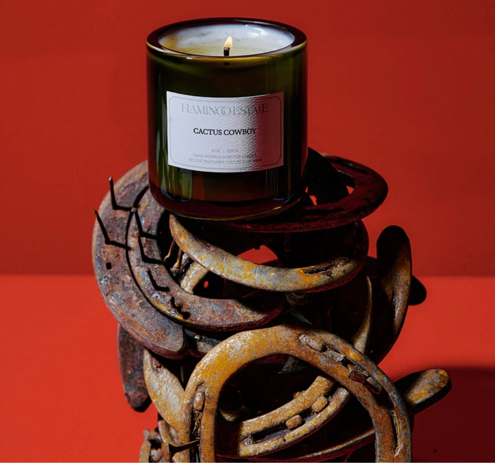 A cactus cowboy candle on top of horse shoes