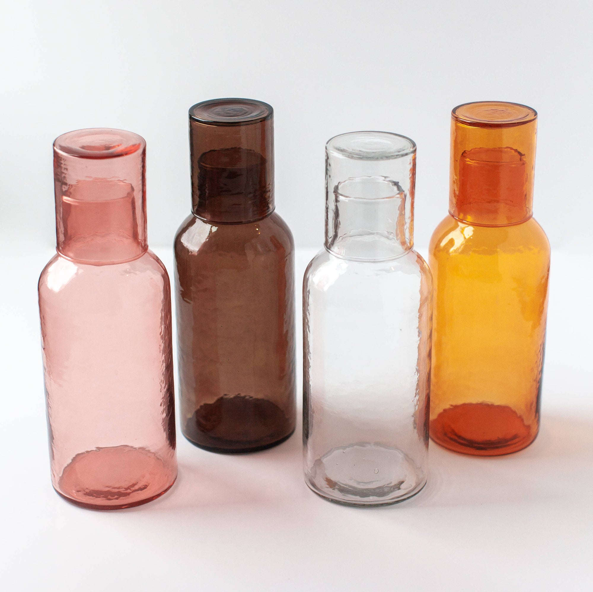 A brown glass decanter with a brown glass lid that serves as a cup. 