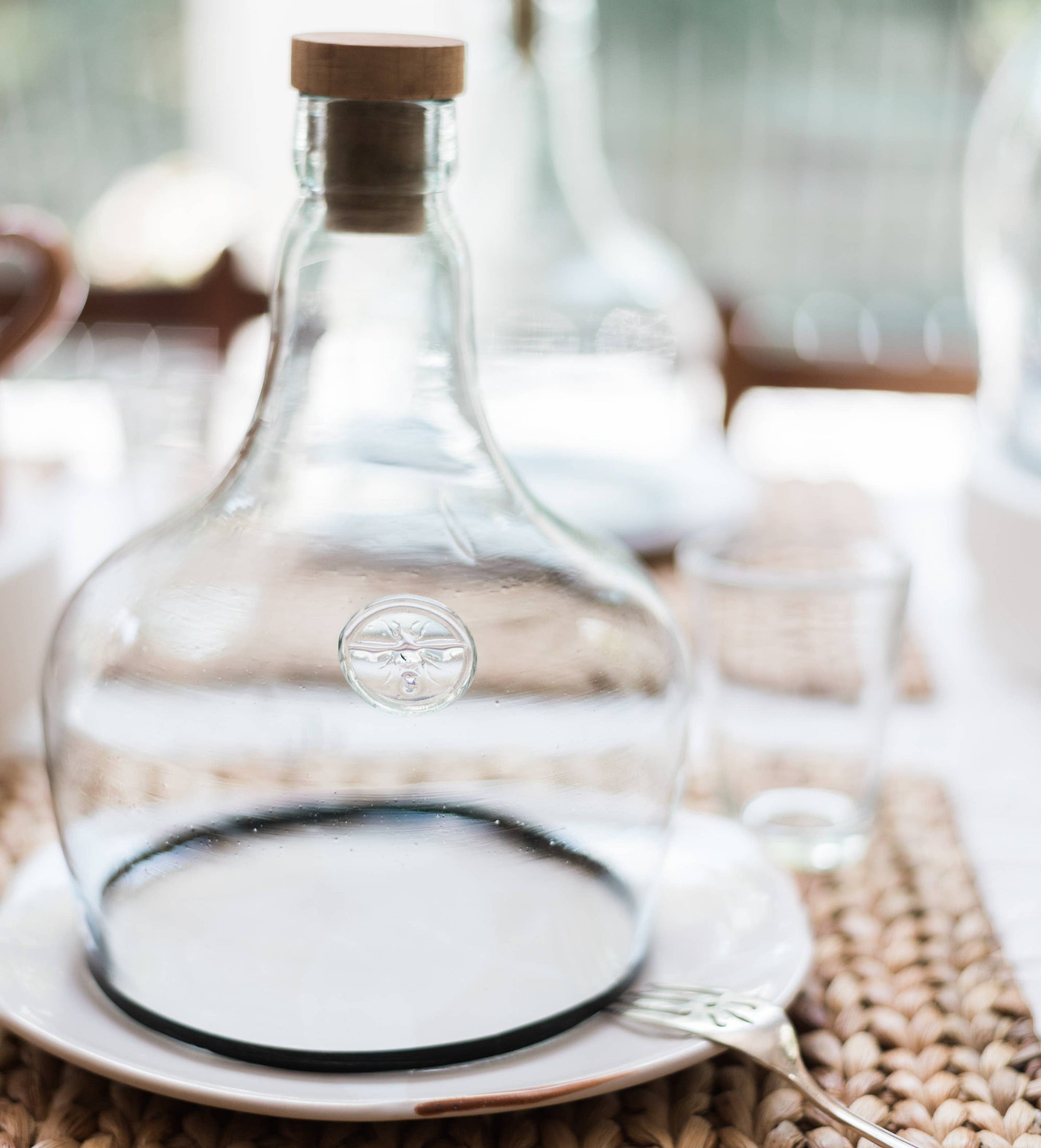 Three glass cloches on a table covering baked goods. 