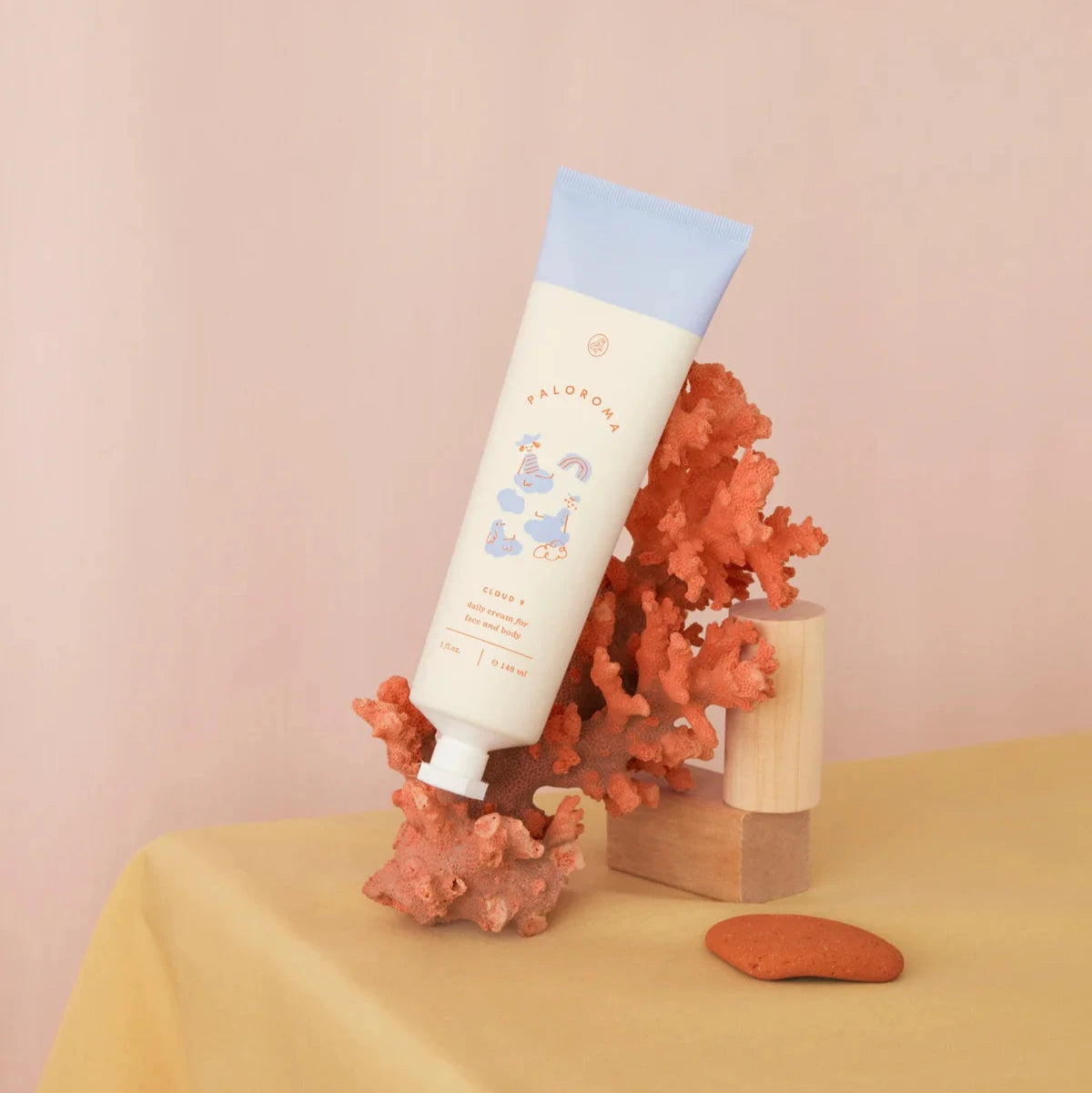 Tube of cream with a blue cap on a pink background