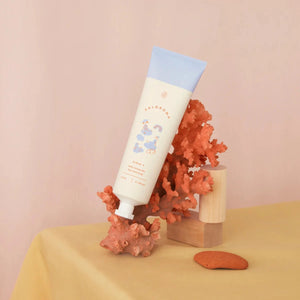 Tube of cream with a blue cap on a pink background