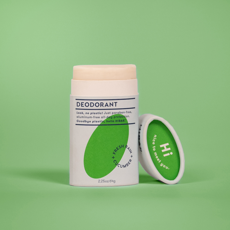 A tube of hi bar fresh rain cucumber deodorant on a green background. 