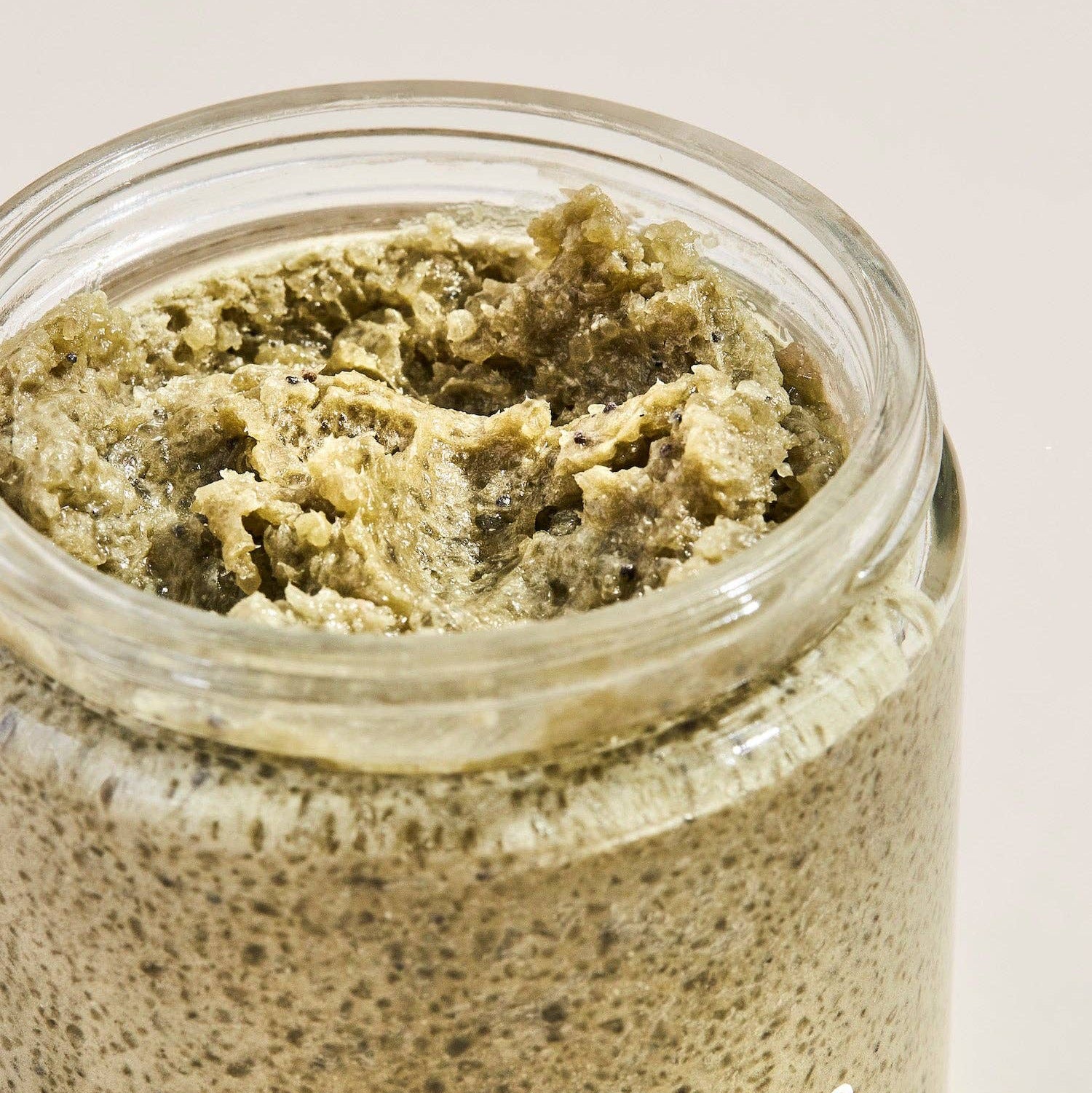 Jar of Palermo Detox Body Scrub with greenish-brown scrub on a light background