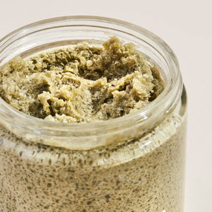 Jar of Palermo Detox Body Scrub with greenish-brown scrub on a light background