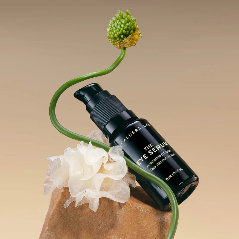 A black pump bottle labeled 'Caldera + Lab | The Eye Serum' with white and gold text on the label.