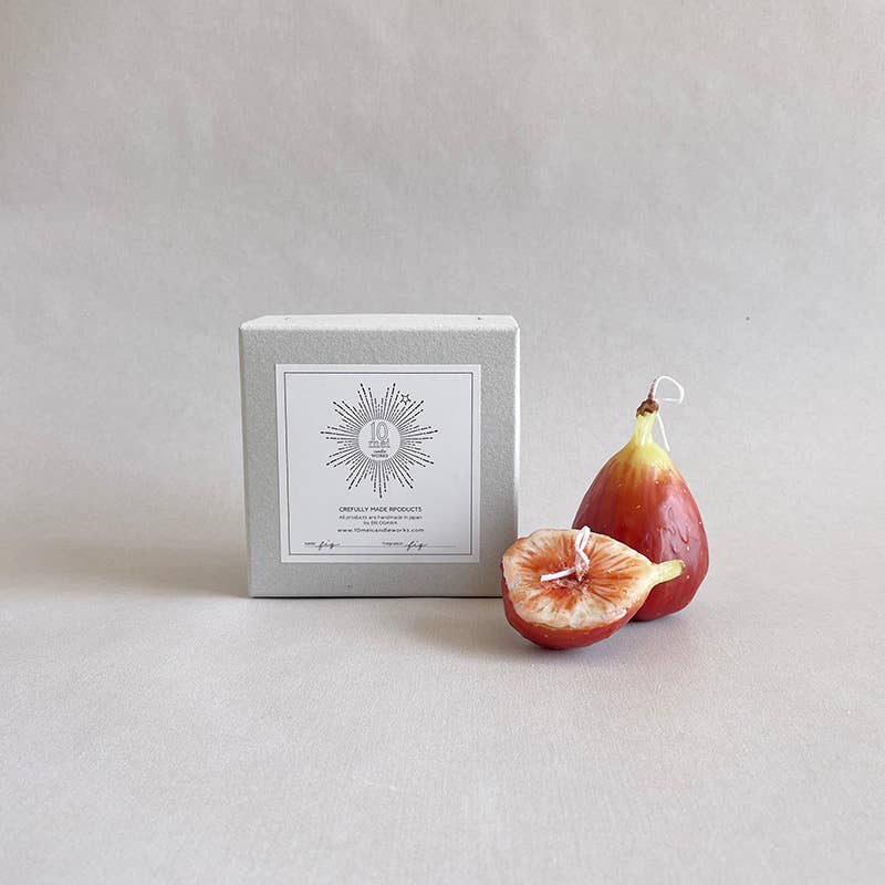 Two fig shaped candles with a light grey box. 
