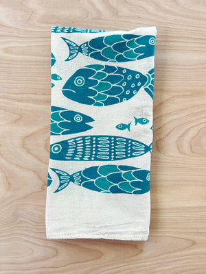 The Noon Designs fish tea towel is white with blue fish printed on it. 