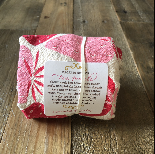 A white kitchen towel with a silkscreened red strawberry pattern.