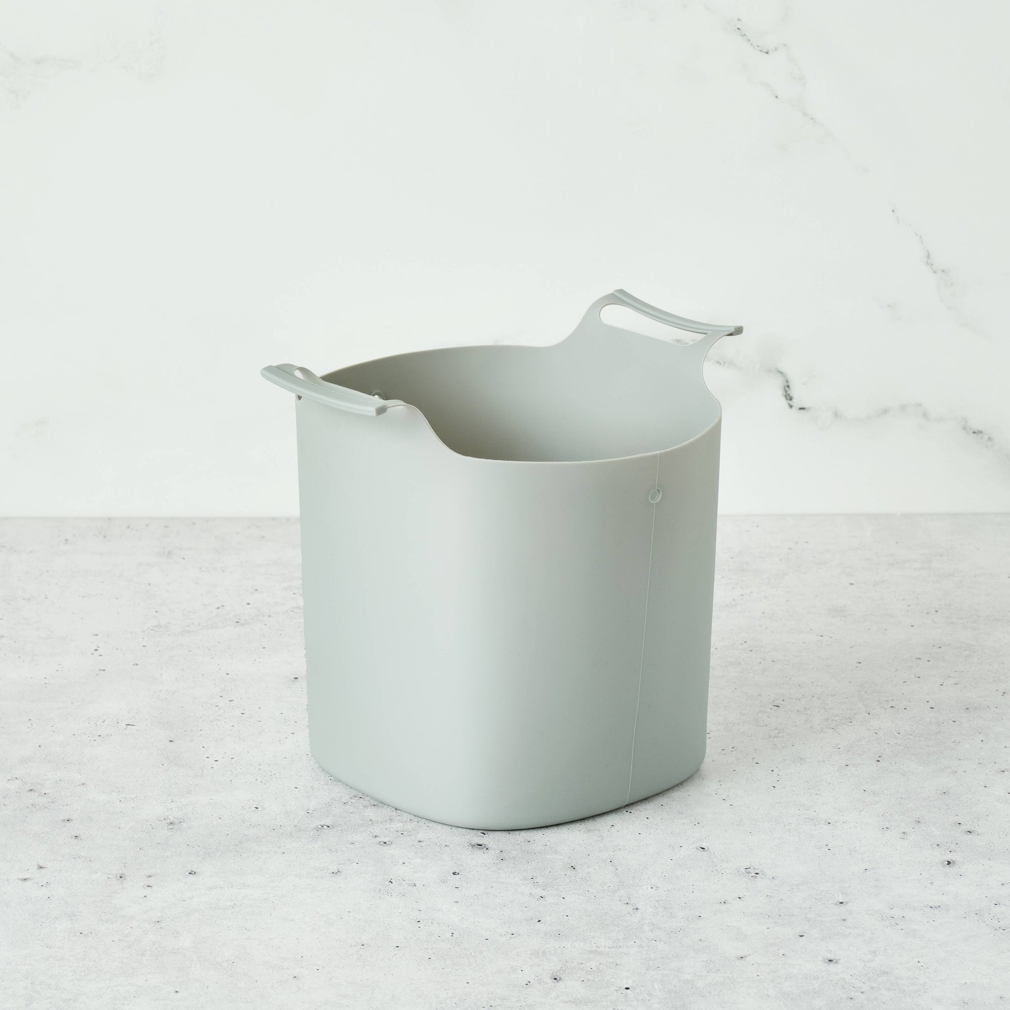 A grey composter liner on a grey surface. 