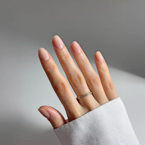 A hand with fingernails wearing kure bazaar tinted nail hardener. 
