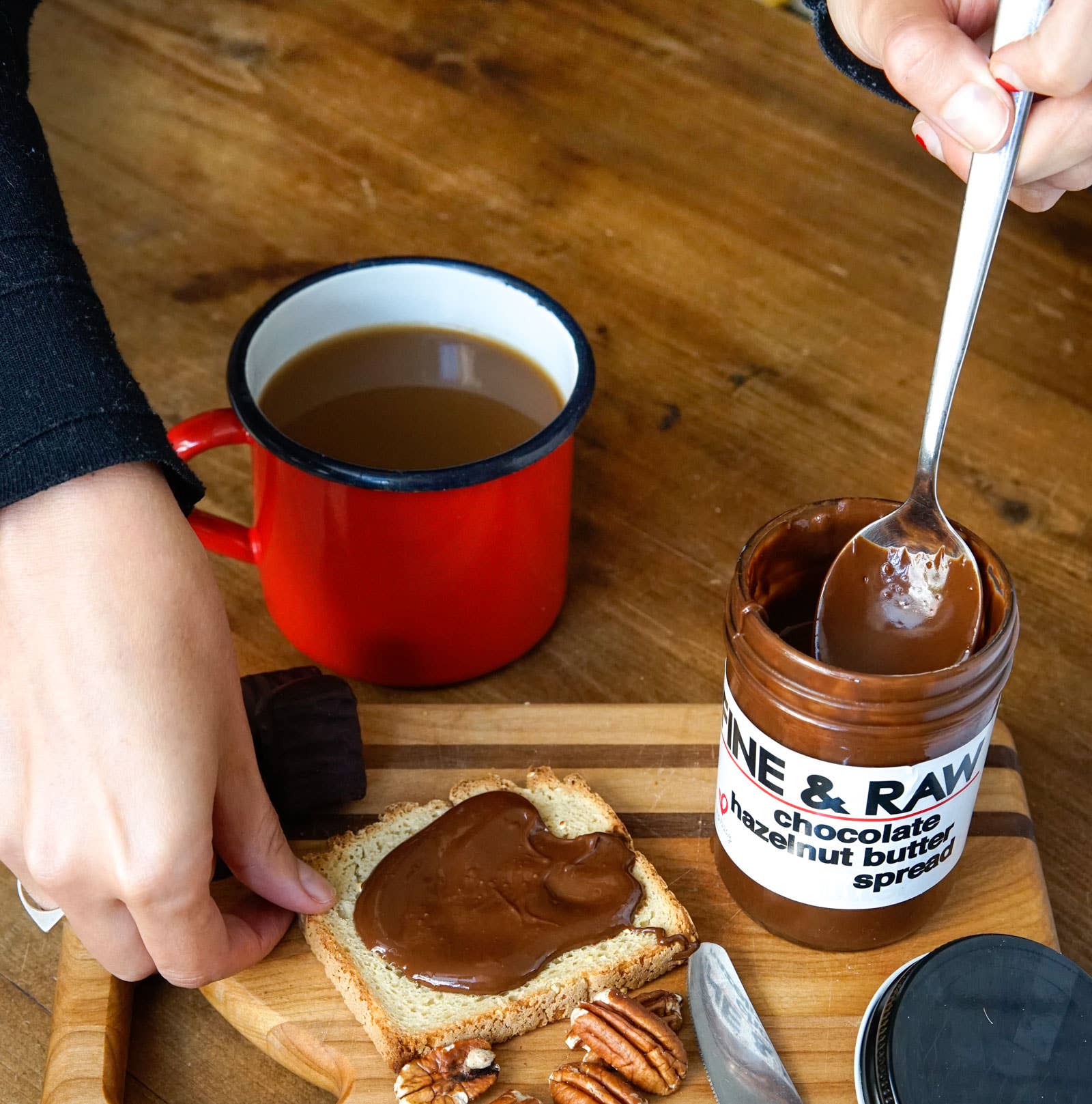 A jar of fine and raw chocolate hazelnut butter spread and a piece of bread