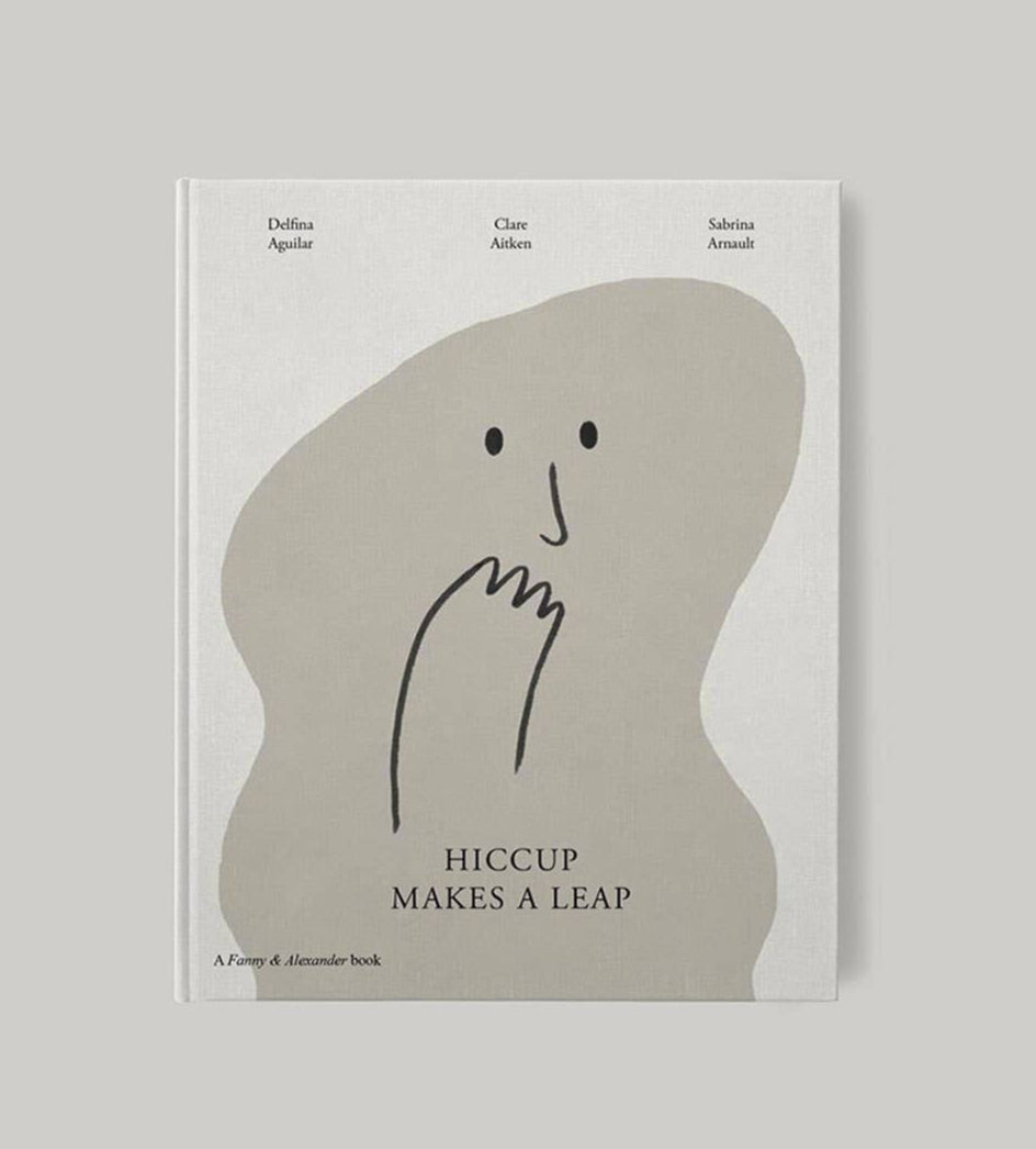 Book cover of 'Hiccup Makes A Leap' featuring a minimalist design with a white background, a drawn illustration of a character resembling a cartoonish face, and text.