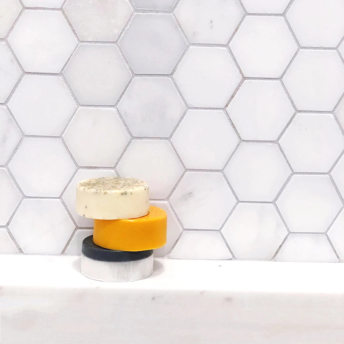 A stack of Meyer lemon soaps next to a rice paper bag with a lemon soap inside.