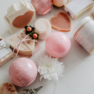 A group pf soak products on a table, including bath bombs, flowers, and soap bars