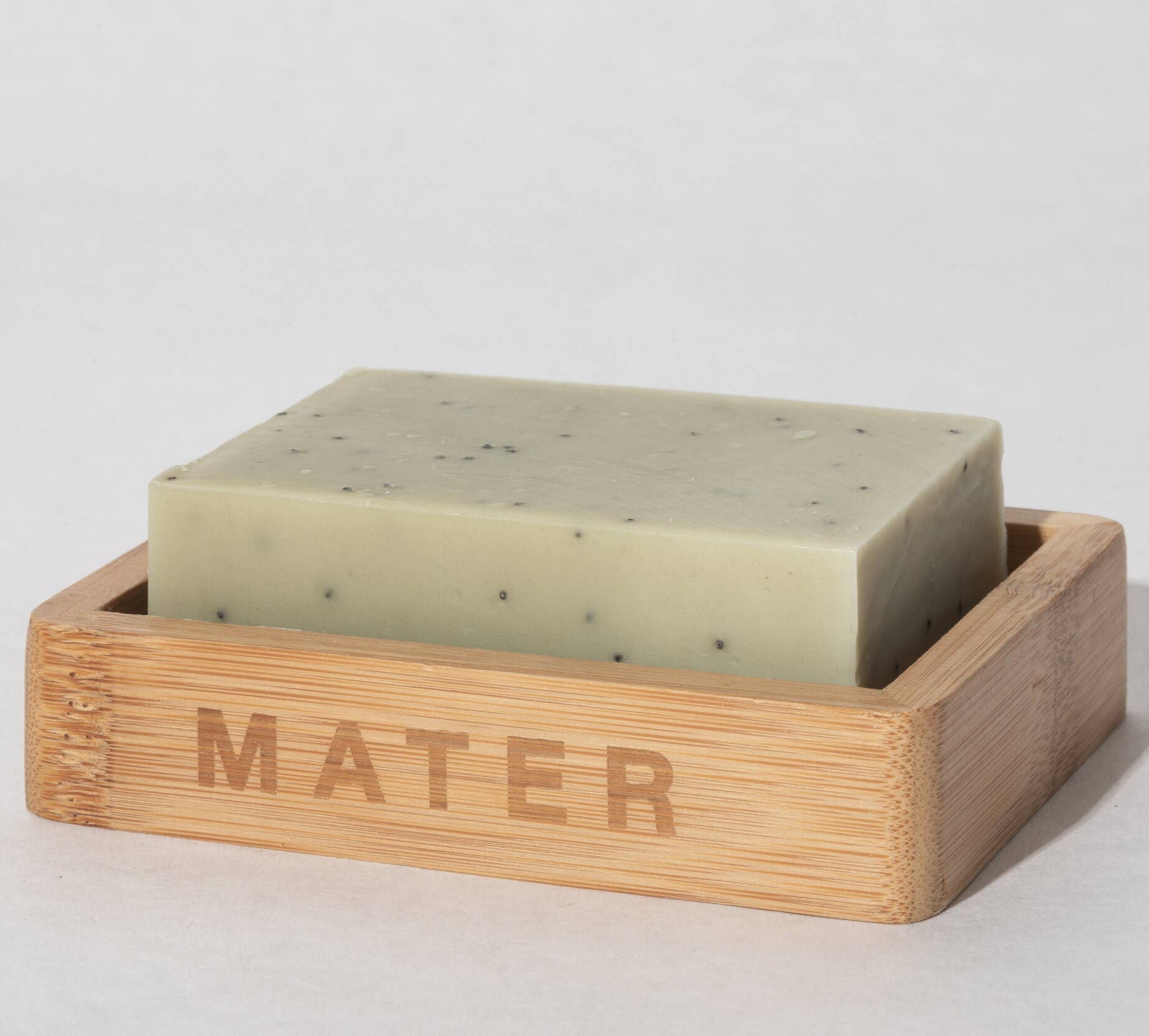 A rectangular bamboo soap dish with 'Mater' engraved on the side.