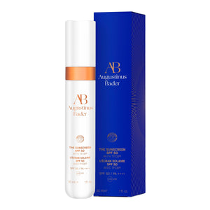 A white bottle of Augustinus Bader The Sunscreen with a blue box