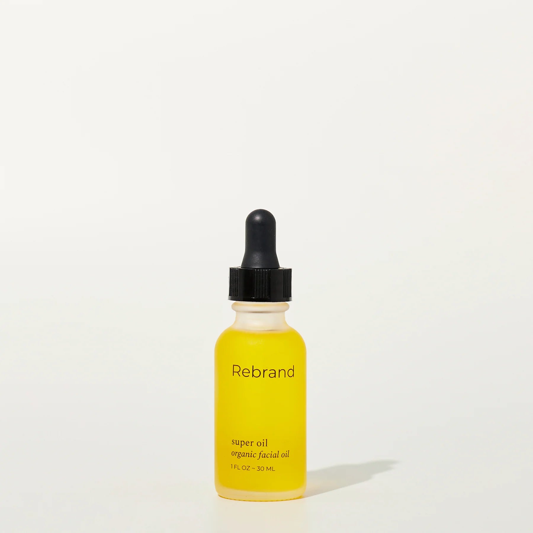 Yellow dropper bottle labeled 'Rebrand' on a white background