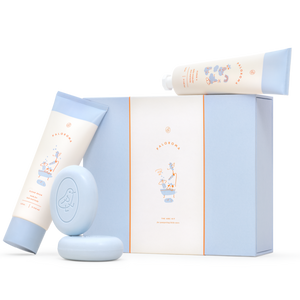 A collection of Paloroma bath time essentials including a wash bottle, a cream bottle, and two cleansing bars, all packaged in a signature Paloroma tissue paper with a bird icon.