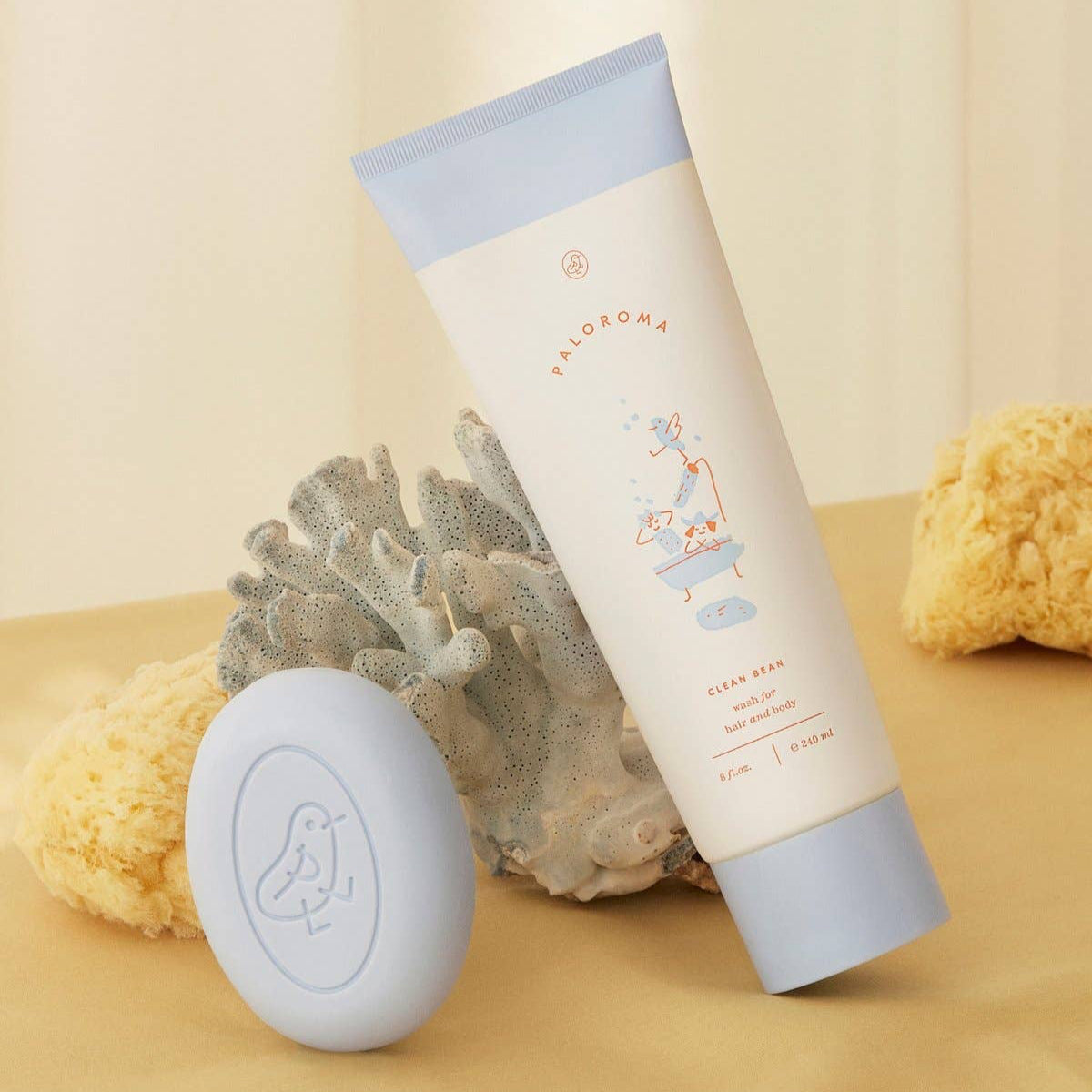 A collection of Paloroma bath time essentials including a wash bottle, a cream bottle, and two cleansing bars, all packaged in a signature Paloroma tissue paper with a bird icon.