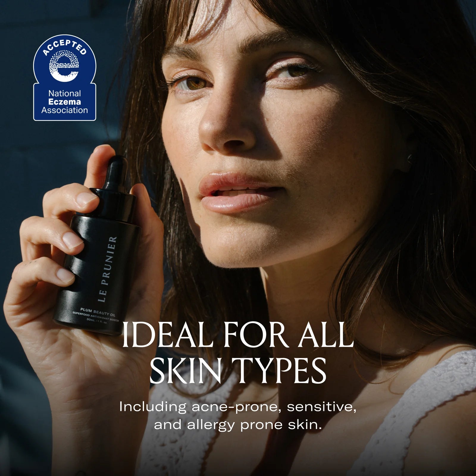 A woman holding a bottle of Plum Beauty Oil, with the heading "Ideal for all skin types."