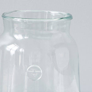 A recycled glass vase with a bee insignia on the side. 
