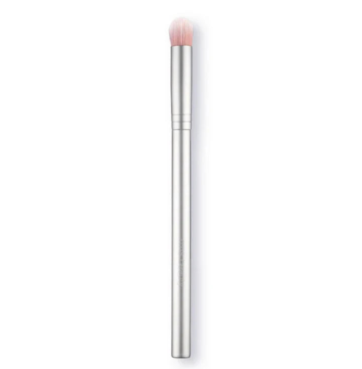A collection of makeup brushes and products including an eye pencil, a brush with imitation goat hair, a tube of cream shadow, and a compact powder.