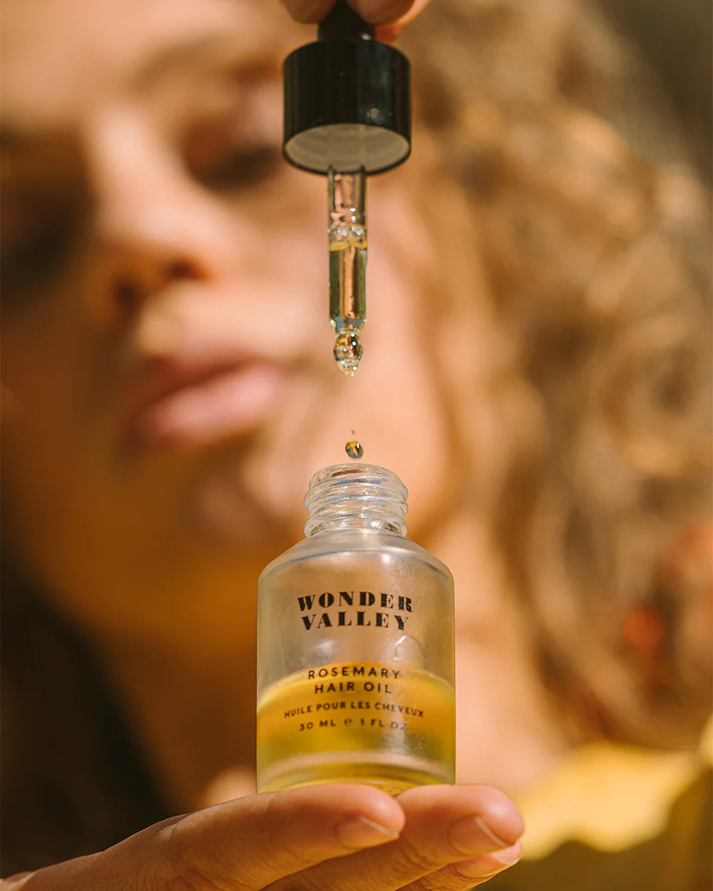 Bottle and box of Wonder Valley hair oil on a white background