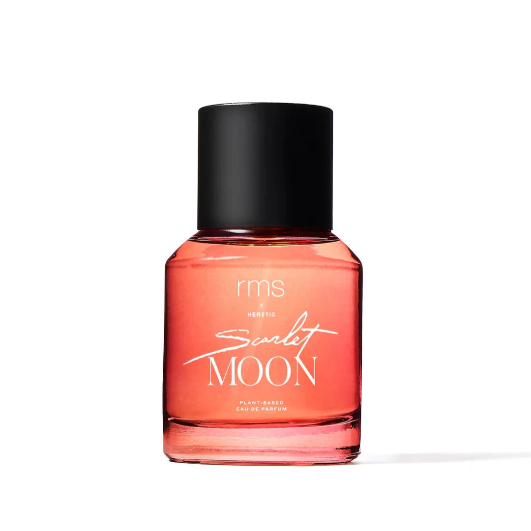 A bottle of RMS Scarlet Moon perfume with a black cap and a pink-reddish liquid inside. The label has 'SCARLET MOON' written in a bold, black font.