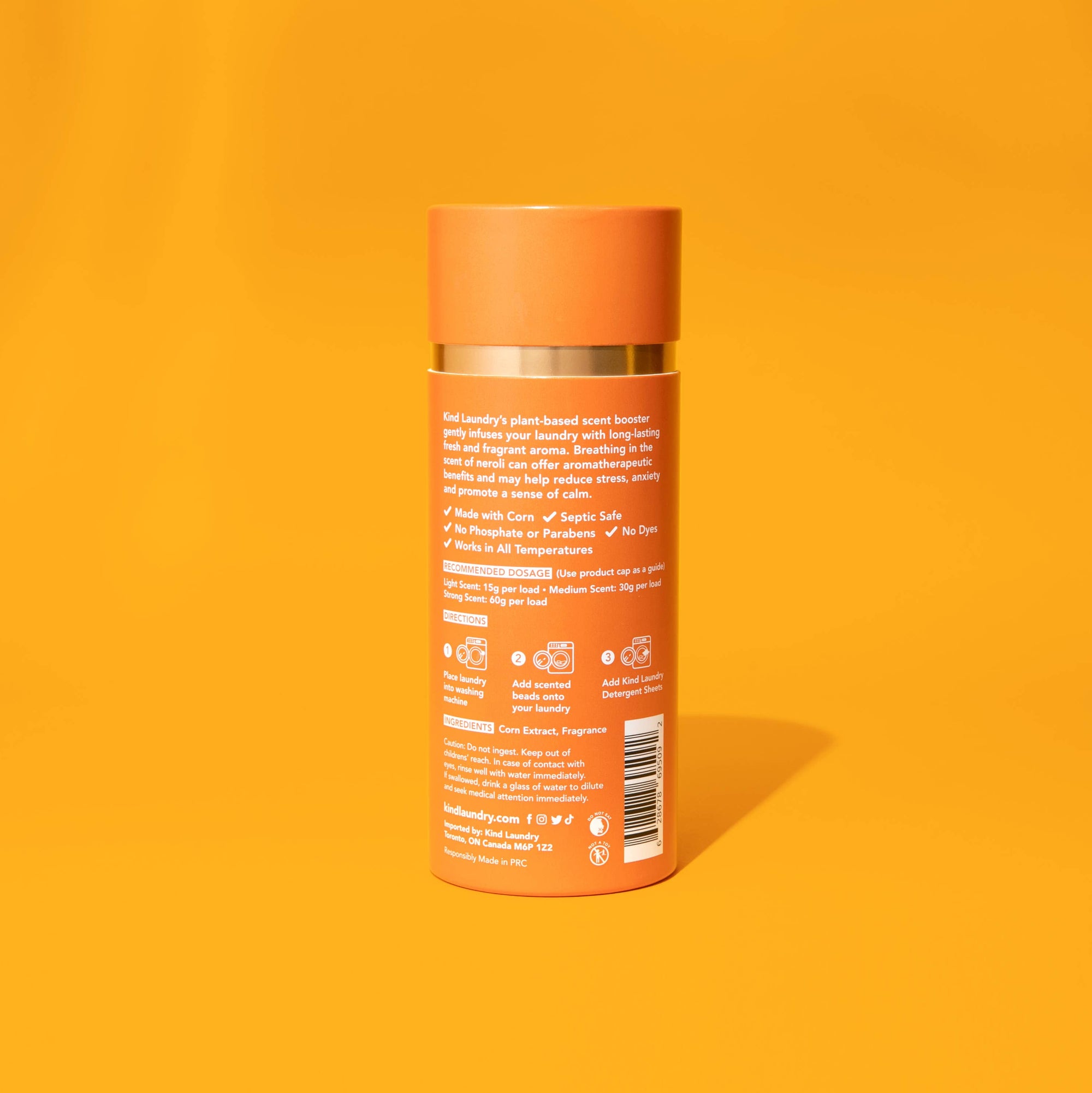 A bottle of Kind Laundry scent boosters on an orange background. 