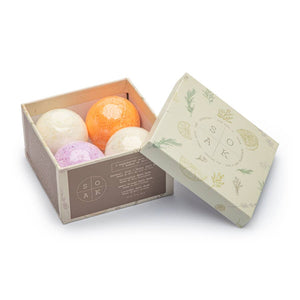 A beige box holding four individual bath bombs