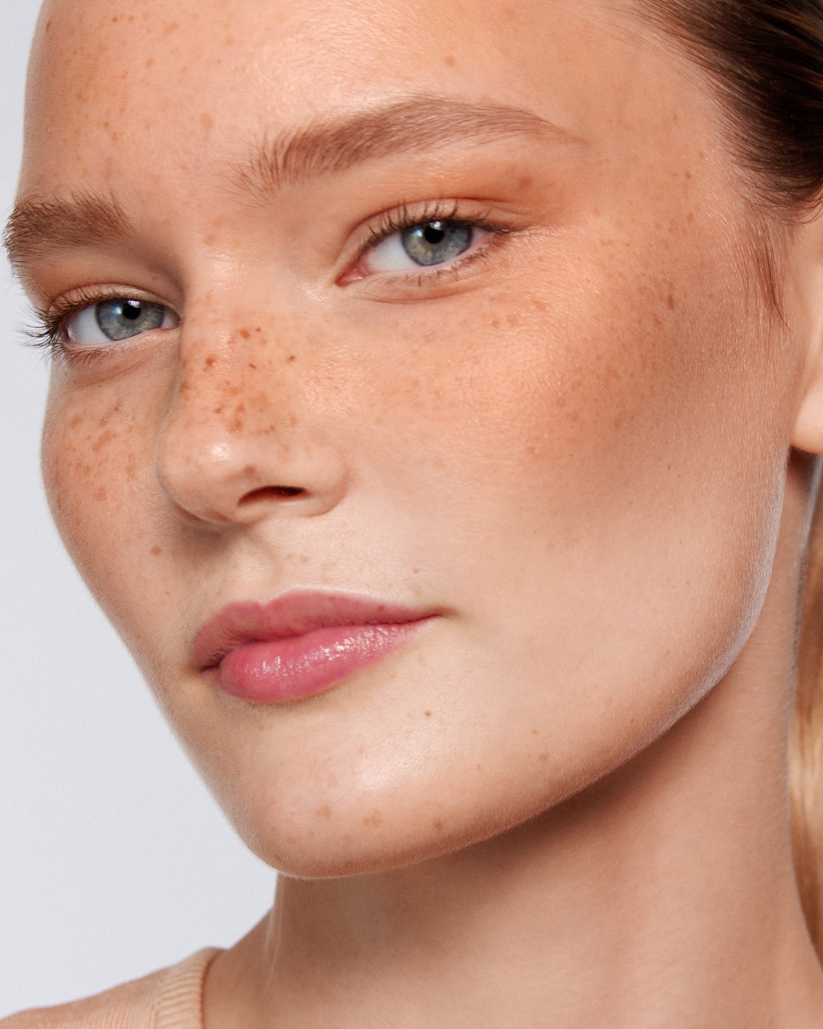 Close-up of a person's face with a neutral background