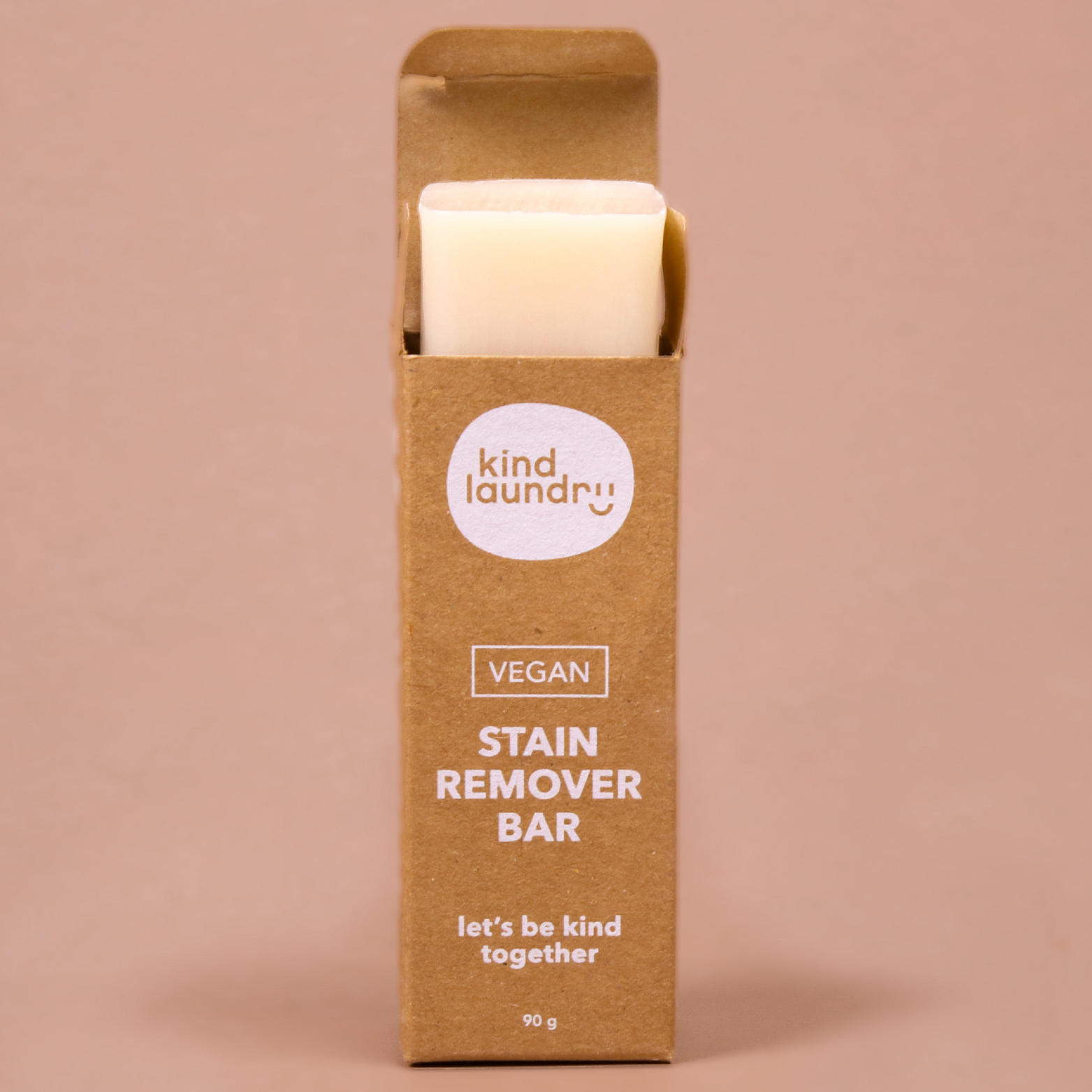 A person holding a stain remover bar on a tile surface, in front of a marble background. 