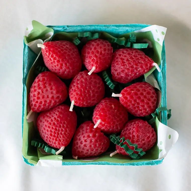 A green produce box full of Happy Organics Strawberry Beeswax Birthday Candles.