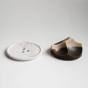 A brown ume studios soap with a grey bouton. 