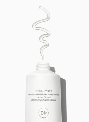 A white bottle of unseen sunscreen with a swatch of clear gel