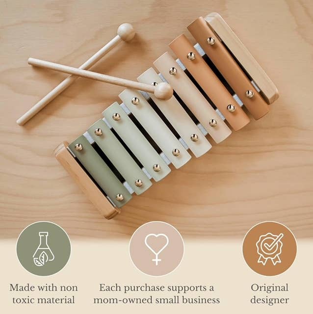 A colorful xylophone on a wood surface. Text reads made with non-toxic materials, each purchase supports a mom-owned small business, and original designer